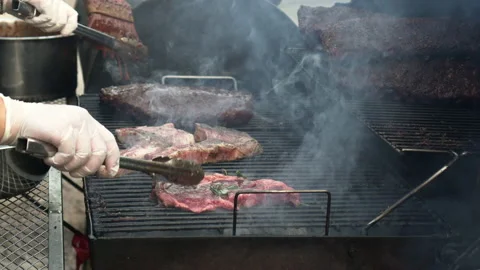 Raw pork chops and ribs meat steaks grilling on stove bbq grill in garden out Stock Footage 205909285