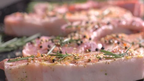 Raw pork chops with bone flavored with a mix of spices Vídeo Stock 106471943