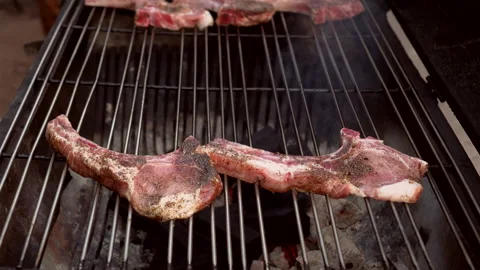 Raw pork chops meat steaks grilling on stove bbq grill in garden outdoor part Stock Footage 205909234
