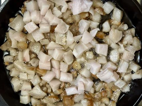 Raw pork fat rendering in pan Stock Photos