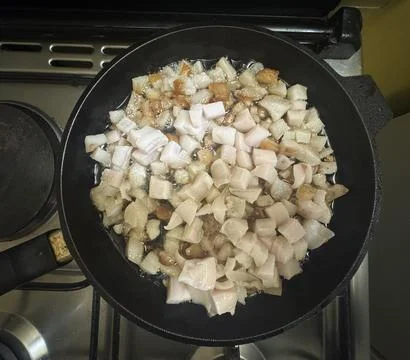 Raw pork fat rendering in pan Stock Photos