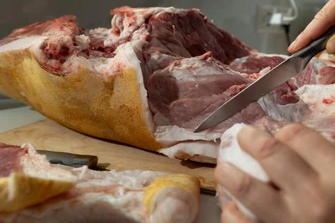 Raw pork leg deboning in a home kitchen: authentic butcher process and textur Stock Photos