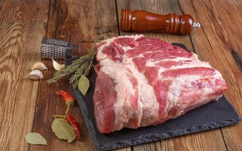 Raw pork ribs. Top the meat ingredient on a slate serving board. close-up.Sel Stock Photos