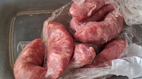 Raw pork sausages inside plastic bag motion video for cooking Stock Footage 339248209