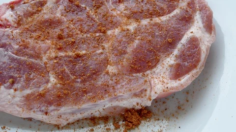 Raw pork is sprinkled with red pepper Stock Footage 97710344