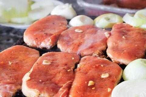 Raw pork steaks on grill Stock Photos