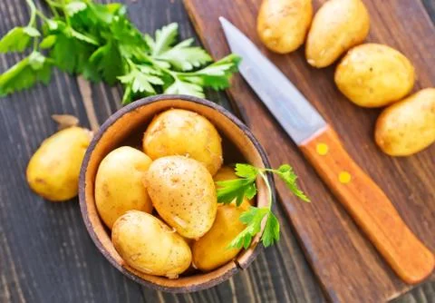 Raw potato on the kitchen table Stock Photos