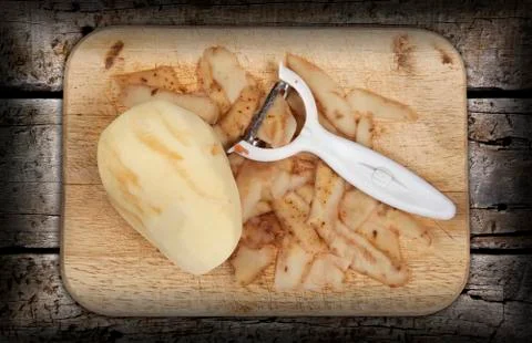 Raw potato peeled and prepared on a chopping board Stock Photos