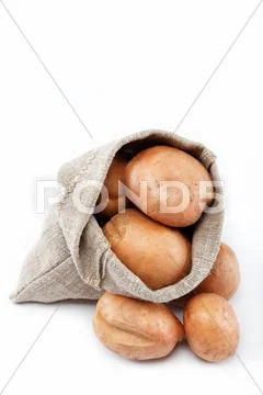 Raw potatoes in burlap bag isolated on white background Stock Photos
