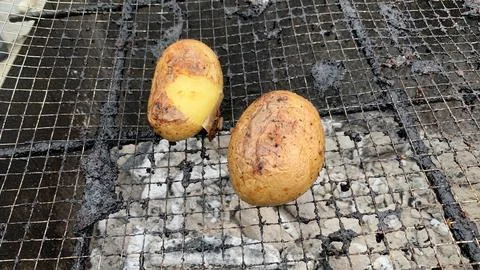 Raw potatoes on the grill Stock Photos