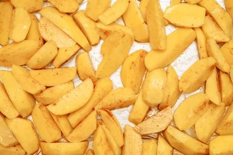 Raw potatoes slices on a baking sheet Stock Photos