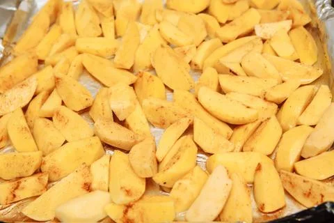 Raw potatoes slices on a baking sheet Foto stock