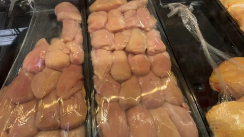 Raw Poultry Fillets Wrapped in Plastic on Market Counter Stockbeeldmateriaal 337910986