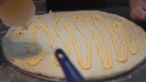 Raw prepared pizza dough is getting saused before baking Stock Footage 143307821