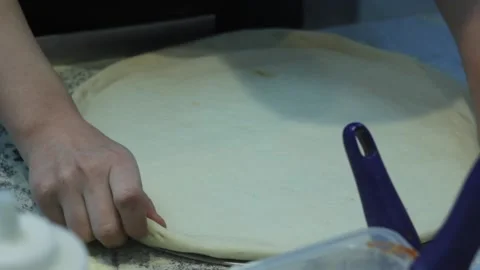 Raw prepared pizza dough is getting saused before baking Stock Footage 144242801