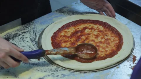 Raw prepared pizza dough is getting saused before baking 스톡 동영상 144243167