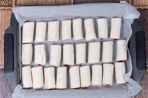 Raw puff pastry stuffed with cherry cream on the baking tray Stock Photos
