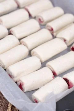 Raw puff pastry stuffed with cherry cream on the baking tray Stock Photos