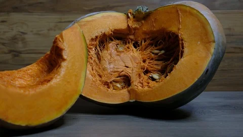 Raw pumpkin cut in half with slice, slider shot Video stock 117751580