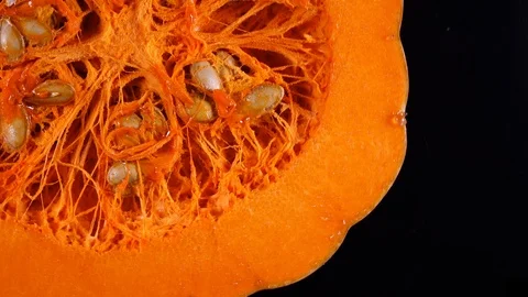 Raw pumpkin with seeds rotating on black background in 4K Vídeos de archivo 89891345