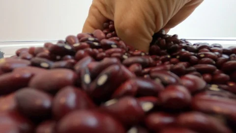 Raw red beans are thrown on the white table with white background. Close up, Stock Footage 128845064