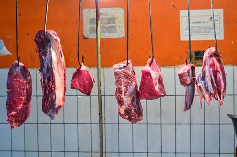 Raw Red Beef Meat Cuts Hanging on Hooks at Traditional Wet Market Stall, Fr.. Stock Photos