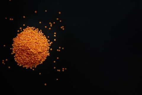 Raw red lentils on a black background. Top view Stock Photos