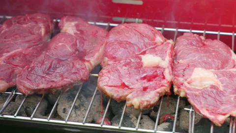 Raw red meat on the grill in 4k Stock Footage 153870595