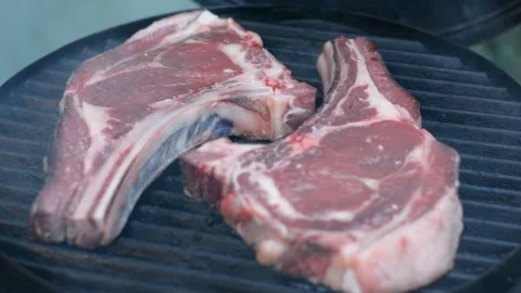 Raw rib steak on the grates of a heated grill Vídeos de archivo 242242450
