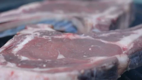 Raw rib steak on the grates of a heated grill Vídeos de archivo 242242457