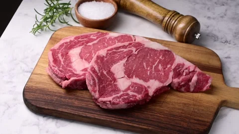 Raw ribeye steak beef on white marble background Stock Footage 260963396