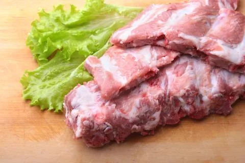 Raw Ribs on a rustic cutting board with salt, pepper . copy space. Stock Photos