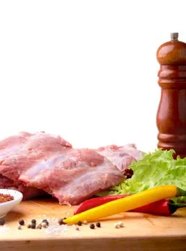 Raw Ribs on a rustic cutting board with salt, pepper and grinder for spices Stock Photos