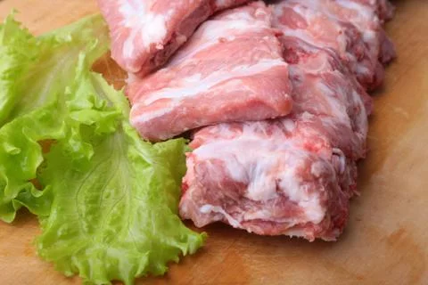 Raw Ribs on a rustic cutting board with salt, pepper and grinder for spices Stock Photos