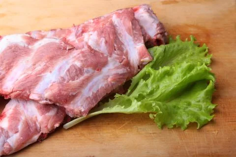 Raw Ribs on a rustic cutting board with salt, pepper and grinder for spices Stock Photos