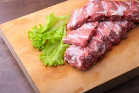 Raw Ribs on a rustic cutting board with salt, pepper and grinder for spices Stock Photos