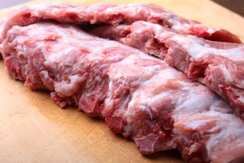 Raw Ribs on a rustic cutting board with salt, pepper and grinder for spices Stock Photos