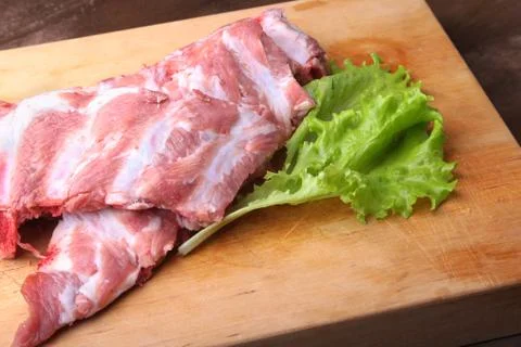 Raw Ribs on a rustic cutting board with salt, pepper and grinder for spices Stock Photos