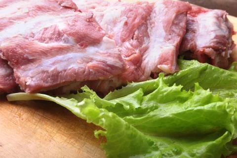 Raw Ribs on a rustic cutting board with salt, pepper and grinder for spices Stock Photos