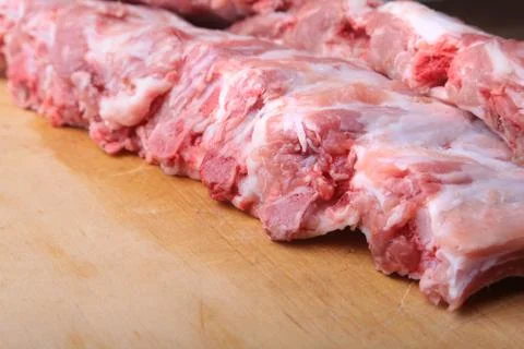 Raw Ribs on a rustic cutting board with salt, pepper and grinder for spices . Stock Photos