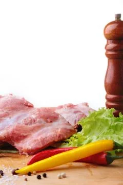 Raw Ribs on a rustic cutting board with salt, pepper and grinder for spices . Stock Photos