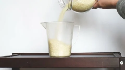 Raw rice grains falling into bowl. Healthy seeds for cooking Stock Footage 170131118