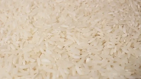 Raw rice grains rotating pattern macro texture background backdrop footage video Stock Footage 91380026