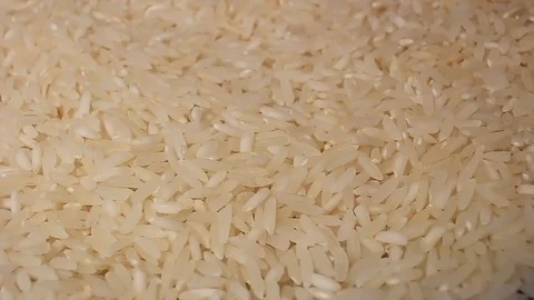Raw rice grains rotating pattern macro texture background backdrop footage video Stock Footage 91380059