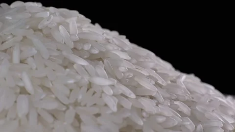 Raw rice grains rotating pattern. White basmati rice grains on black background Stock Footage 115835734