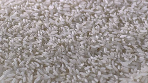 Raw rice grains rotating pattern. Pile of cereal long seeds rice close up. White 스톡 동영상 115845446