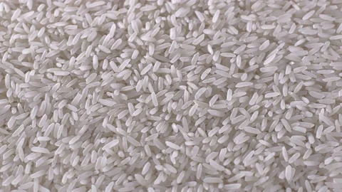 Raw rice grains rotating pattern. Pile of cereal long seeds rice close up. White Stock Footage 115887008