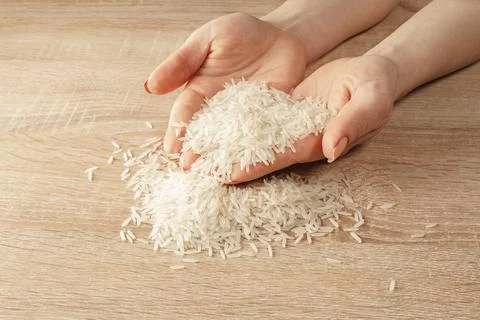 Raw rice in hands Stock Photos