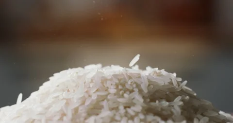 Raw rice poured pile, side view home kitchen blurred background Asian Chinese Stock-Footage 243818883
