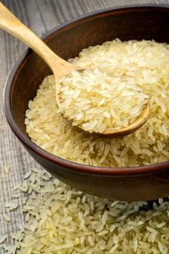 Raw rice in spoon Stock Photos
